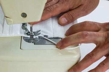 Surgical face mask is sewn on the sewing machine,close up