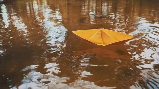 bluei paper sailboat sailing on water. River,