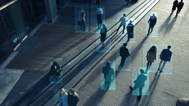 Elevated Security Camera Surveillance Footage of a Crowd of People Walking on Busy Urban City Streets. CCTV AI Facial Recognition Big Data Analysis Interface Scanning, Showing Animated Information