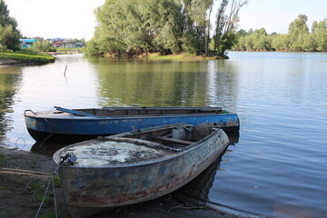 Naklejka na ściany i meble old boats on the river Bank in the summer in a Siberian village