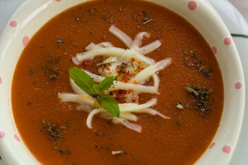 Traditional Turkish Tomato Soup with cheese and fresh mint garnised,close-up taken on Ramadan,Iftar Table.