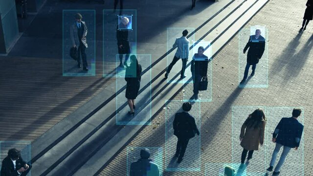 Elevated Security Camera Surveillance Footage of a Crowd of People Walking on Busy Urban City Streets. CCTV AI Facial Recognition Big Data Analysis Interface Scanning, Showing Information. Zoom in
