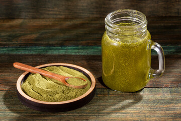 Organic green smoothie in the glass jar - Wood background
