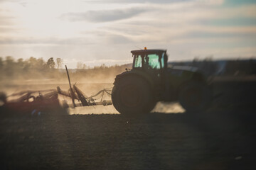 Tractor with a disc harrow system harrows the cultivated farm field, process of harrowing and...