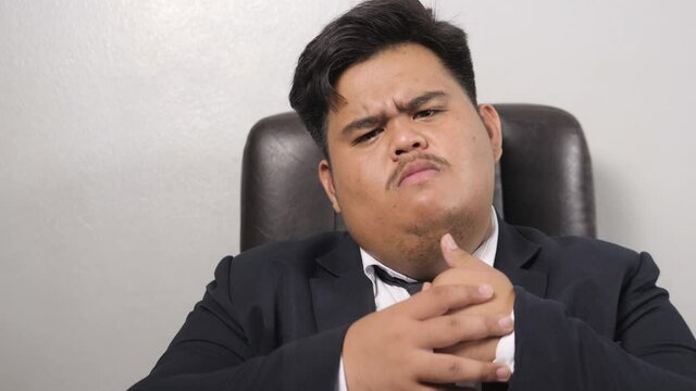 A funny Asian fat business man wearing a suit look like the head of corporate executive or business manager feel very angry, not happy, showing a gesture of contention but still funny.