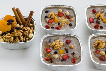 Traditional Turkish Dessert is Noah's Pudding,Asure in foil containers ,take away package,on the white surface with copy space.