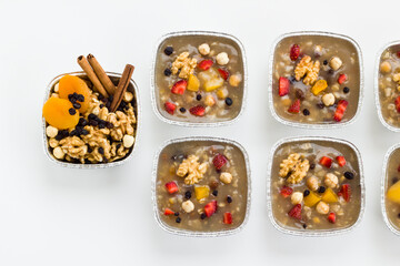 Traditional Turkish Dessert is Noah's Pudding,Asure in foil containers ,take away package,on the white surface with copy space.