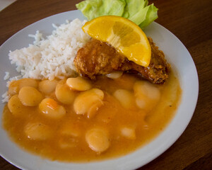 Typical dish of large beans, rich sauce and fried fish at local 