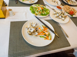 Vietnamese appetizer of  mussels and raw vegetable salad of carrots and zucchini. 