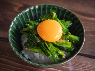 温かいご飯の上に乗せた卵黄とニラのピリ辛和え。