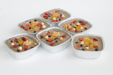 Traditional Turkish Dessert is Noah's Pudding,Asure in foil containers ,take away package,on the white surface with copy space.