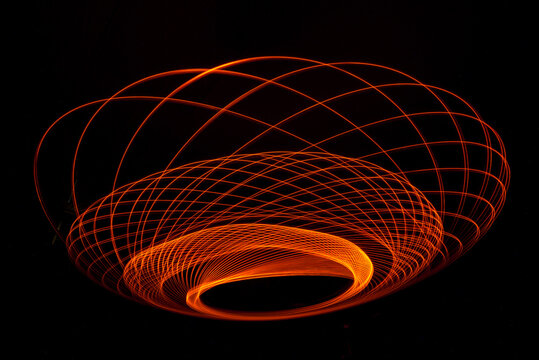 Wonderful and abstract circular and parabolic patterns drawed various light trails with LED ball lights on a dark back ground,Pendulum. 