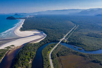 Foto aérea das montanhas incluindo as curvas e formas do rio com a rodovia ao lado.
