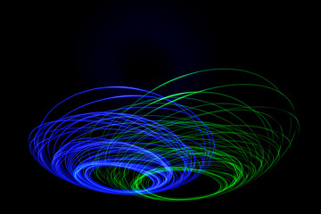 Wonderful and abstract circular and parabolic patterns drawed various light trails with LED ball lights on a dark back ground,Pendulum. 