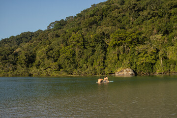 Fototapeta na wymiar Casal nadando em águas do rio Guaratuba
