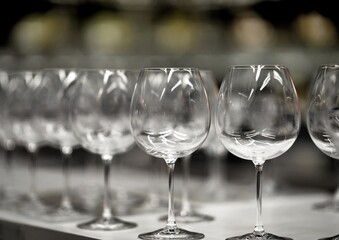 a row of glass round glasses on a high leg on the table