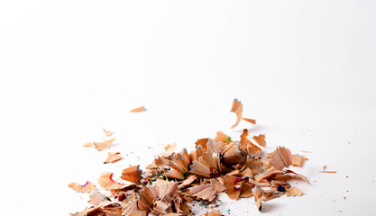 Shavings of red pencil in close-up on a white background. Pencil lead whole and broken on a white background. Leftovers from a pencil. Macro, a pile of shavings