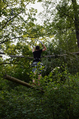 The guy goes through the obstacle course on the rope park