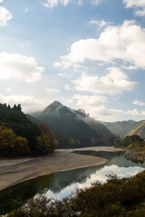 朝靄の発生した山と川と青空