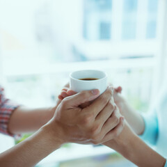 Couple in love holding hands and holding coffee cup