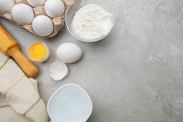 Baking cooking ingredients flour eggs rolling pin and kitchen textiles on gray concrete background. Cookie pie or cake recipe mockup
