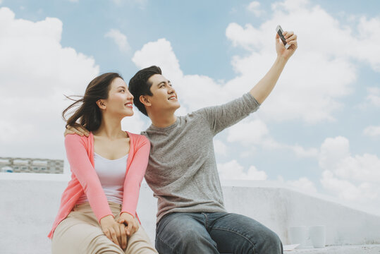 Young Asian Couple taking photo/ selfie on a rooftop