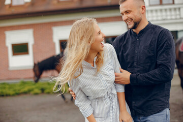 Couple in a summer rainy park. Pair standing with a horse. Girl in a white dress