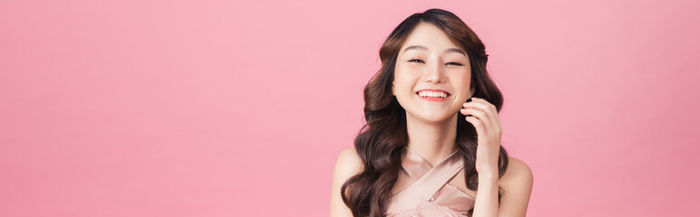 Fototapeta premium Asia piękna kobieta nosi różową sukienkę. Stojąc przed różowym tłem.