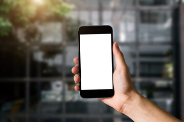 Hand holding white mobile phone with blank white screen in cafe.
