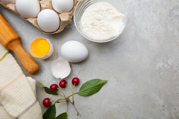 Ingredients baking flour eggs rolling pin berries kitchen textiles on gray background. Cookie pie or cake recipe mockup. Background preparation for culinary baking.
