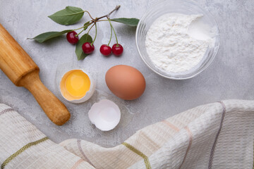 Ingredients baking flour eggs rolling pin berries kitchen textiles on gray background. Cookie pie or cake recipe mockup. Background preparation for culinary baking.