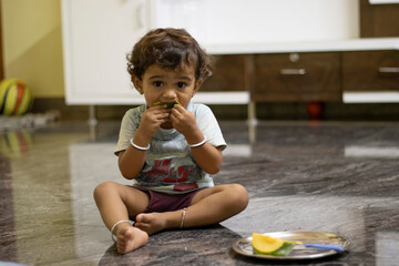 a little child eating mango fruits , indoors boys