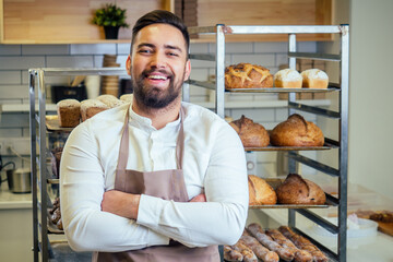 Handsome baker in uniform at the manufacturing small business owner concept