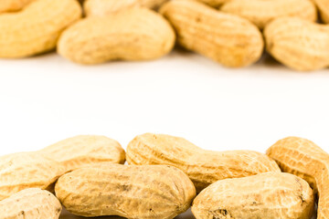 some dried and closed peanuts isolated on white background with copy space