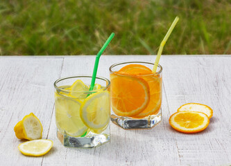 glasses with a refreshing drink of lemons and oranges