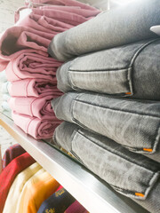 A Closeup side angle view of a stack of pants placed on the shelf.