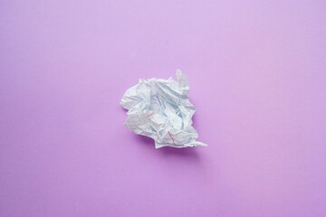 A crumpled sheet of white paper in a cage on a purple background.