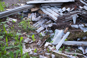 Broken asbestos cement sheets in nature, toxic waste