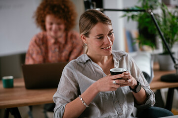Young businesswoman drinking coffee in her office	
