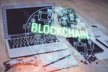 Double exposure of blockchain and crypto economy theme hologram and table with computer background. Concept of bitcoin cryptocurrency.