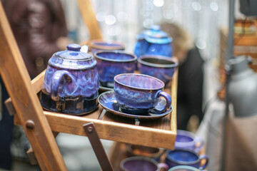 Ceramic dishes: blue cups, plates, saucers, teapots. On a wooden shelf