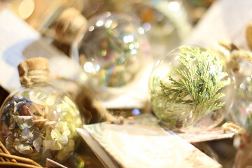 New Year's glass transparent Christmas ball with coniferous branches and dried flowers lies in a basket
