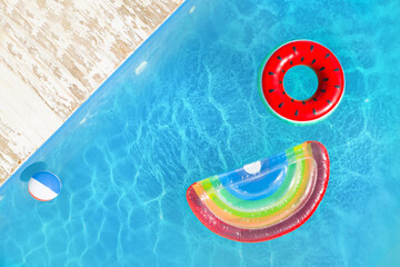 Fototapeta na wymiar Swimming pool with inflatable ring, mattress and ball, top view