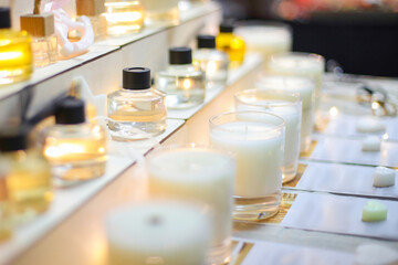 Scented candles for home with various compositions. Perfumed smells in bottles. Stand at exhibition...