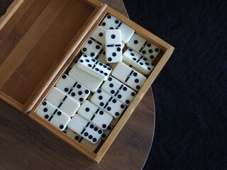open wooden box with white dominoes lies on the table
