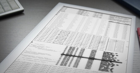 Sheet of white paper with digital numbers and code lies on table