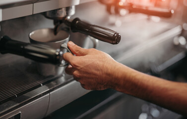 Barista preparing fresh coffee in coffee machine