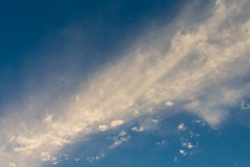 White fluffy clouds are spread across the blue sky, directed diagonally.