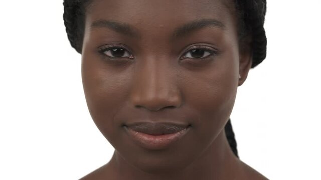 Close-up portrait of young black woman looking at camera and shaking her head. Isolated on white background