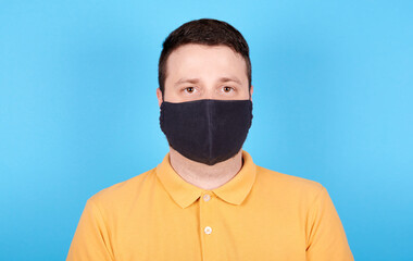 Potrait of brunette man in protection mask. Isolated on blue background.